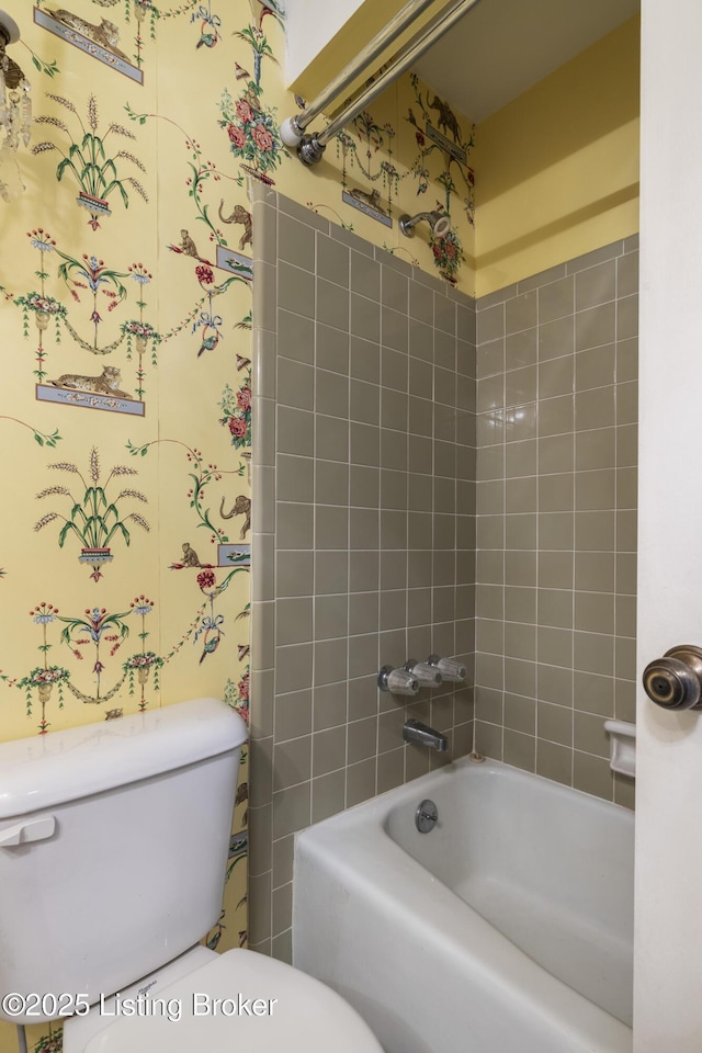 bathroom with toilet and tiled shower / bath combo