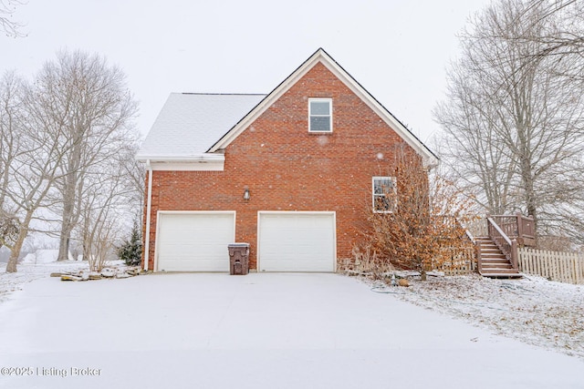 view of snow covered exterior with a garage