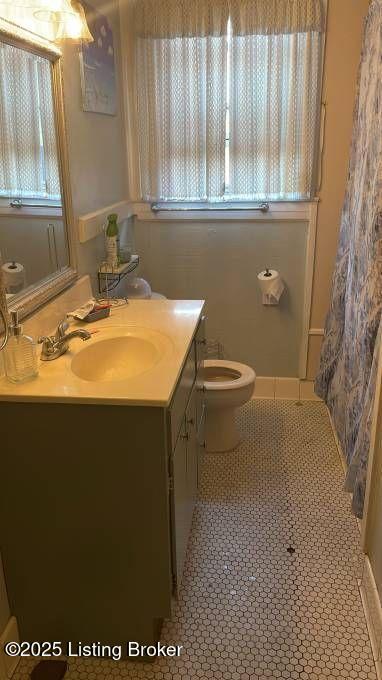 full bathroom featuring toilet, a shower with shower curtain, vanity, and tile patterned floors