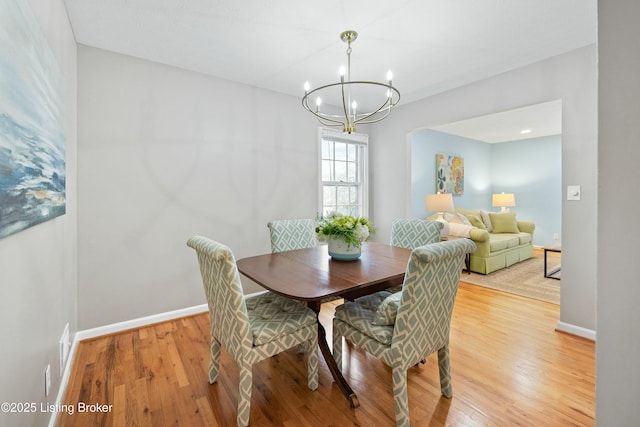 dining space featuring hardwood / wood-style flooring and a chandelier