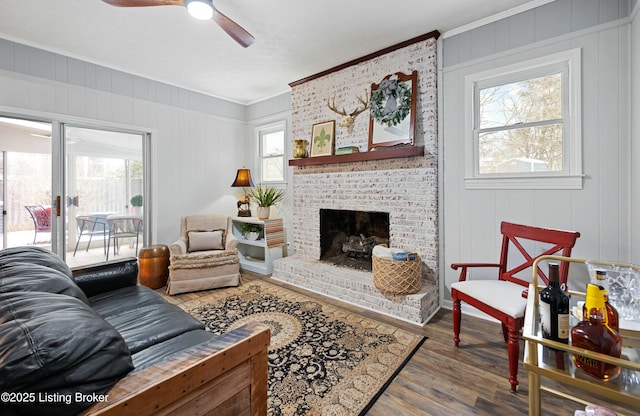 living room featuring hardwood / wood-style flooring, ornamental molding, plenty of natural light, and a fireplace