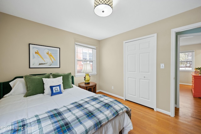 bedroom featuring multiple windows and light hardwood / wood-style flooring