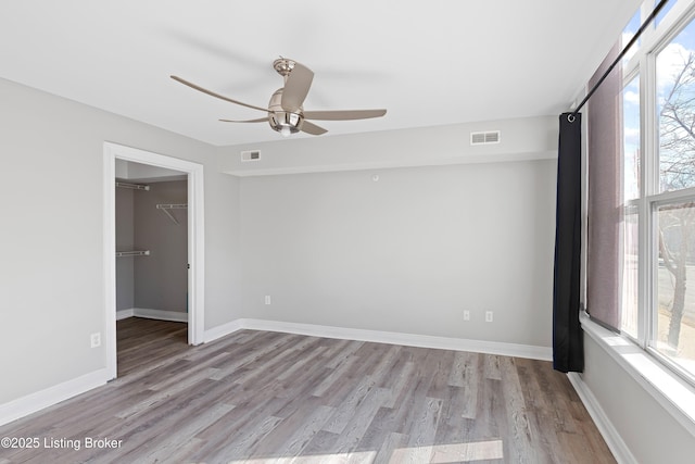 unfurnished room with plenty of natural light, visible vents, and light wood-type flooring