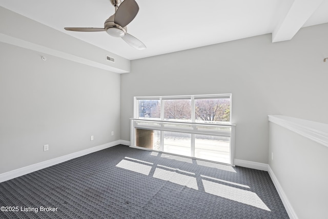 spare room with visible vents, ceiling fan, baseboards, beam ceiling, and dark colored carpet