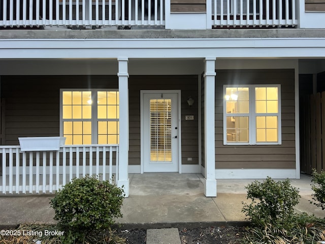 doorway to property with covered porch and a balcony