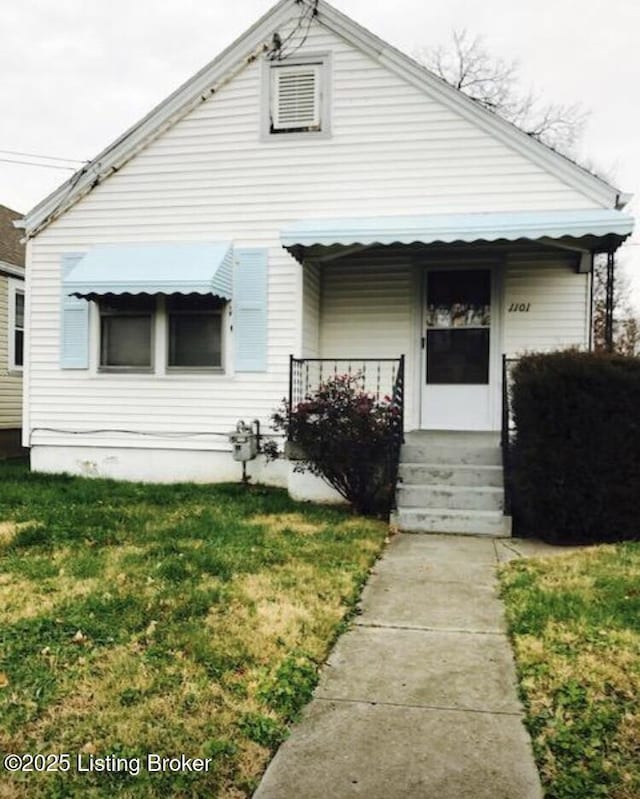 bungalow-style home with entry steps and a front lawn