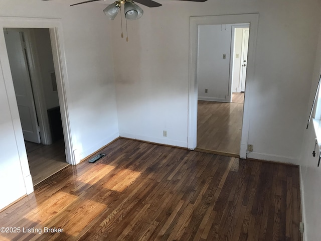 unfurnished room featuring a ceiling fan, baseboards, and dark wood-style flooring