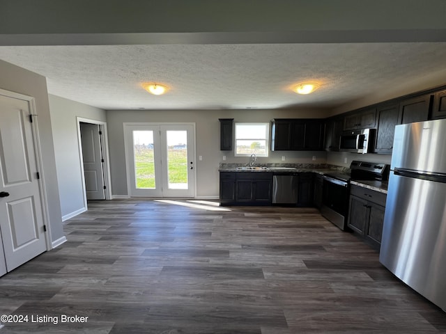 kitchen featuring dark hardwood / wood-style flooring, sink, dark brown cabinets, and appliances with stainless steel finishes