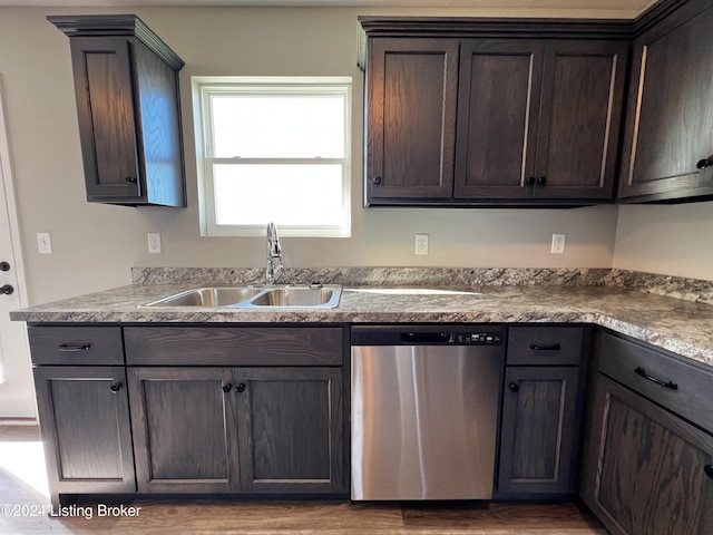 kitchen featuring stainless steel dishwasher, dark brown cabinetry, sink, and light wood-type flooring