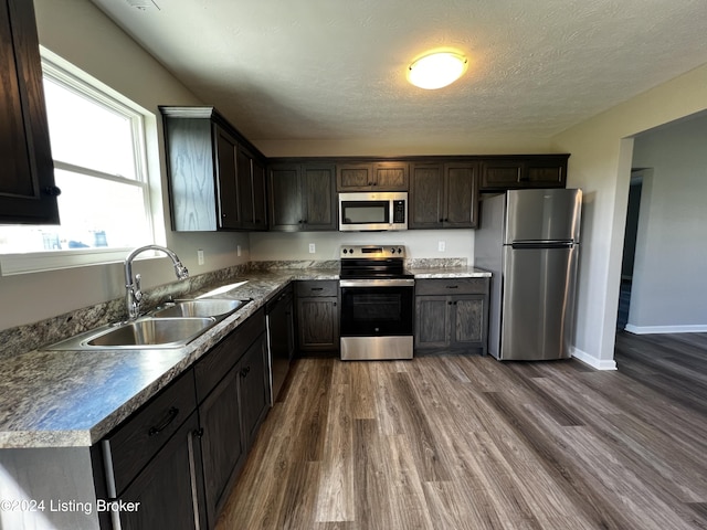 kitchen featuring stainless steel appliances, dark hardwood / wood-style floors, sink, and dark brown cabinets