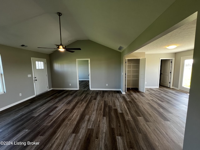 unfurnished living room featuring ceiling fan, dark hardwood / wood-style floors, and vaulted ceiling