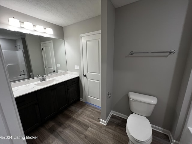 bathroom with vanity, hardwood / wood-style floors, a textured ceiling, and toilet