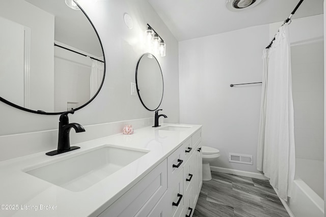 full bathroom featuring shower / bathtub combination with curtain, vanity, and toilet