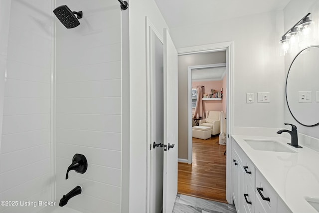 bathroom with tiled shower / bath combo, vanity, and hardwood / wood-style floors