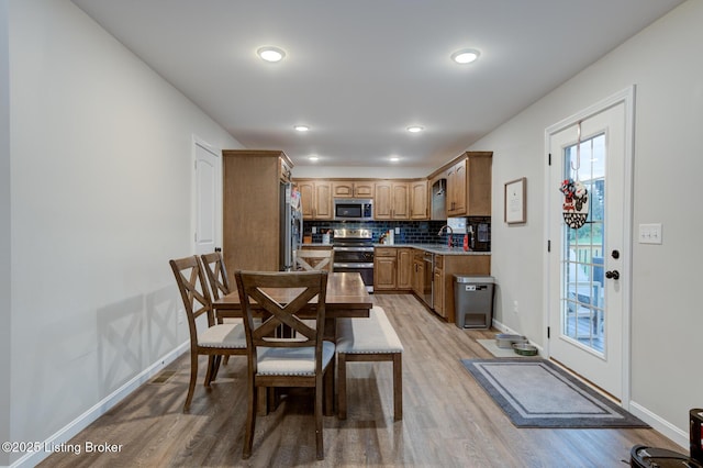 dining area with sink and light hardwood / wood-style flooring