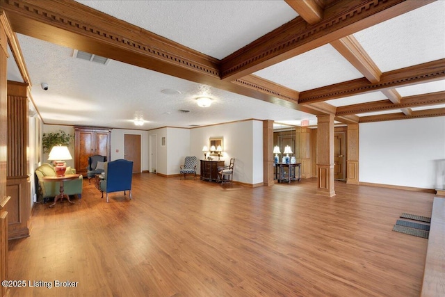 unfurnished living room with ornate columns, light wood-type flooring, a textured ceiling, and beam ceiling