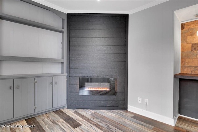 unfurnished living room with ornamental molding, wood-type flooring, and a fireplace