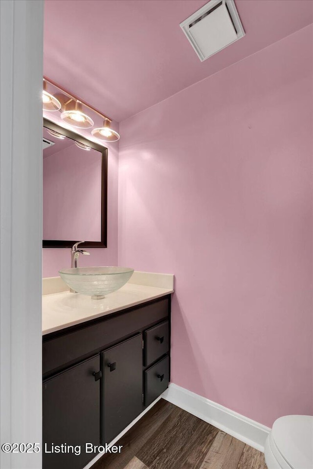 bathroom featuring hardwood / wood-style flooring, vanity, and toilet