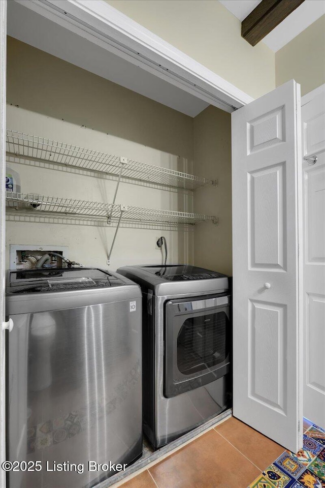 laundry room featuring washer and clothes dryer and light tile patterned flooring