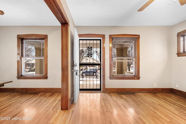 entryway featuring ceiling fan, a healthy amount of sunlight, and light wood-type flooring