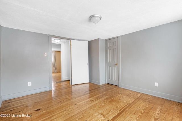 unfurnished bedroom with a textured ceiling and light wood-type flooring