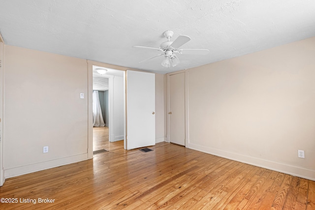 unfurnished room with light hardwood / wood-style floors and a textured ceiling