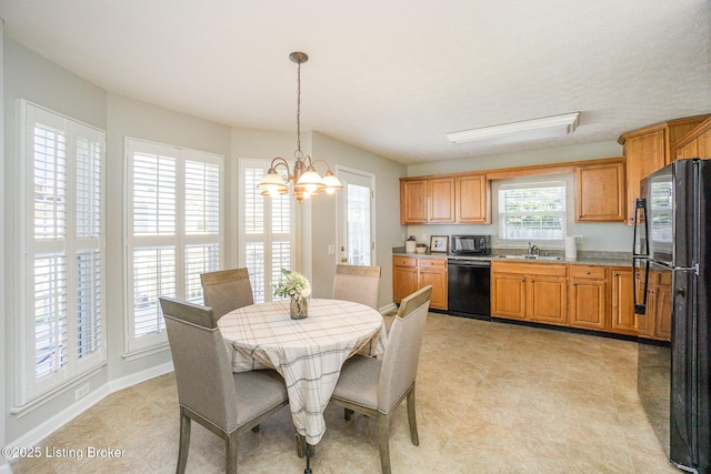 dining space featuring sink and a chandelier