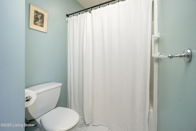 bathroom featuring shower / bath combination with curtain and toilet