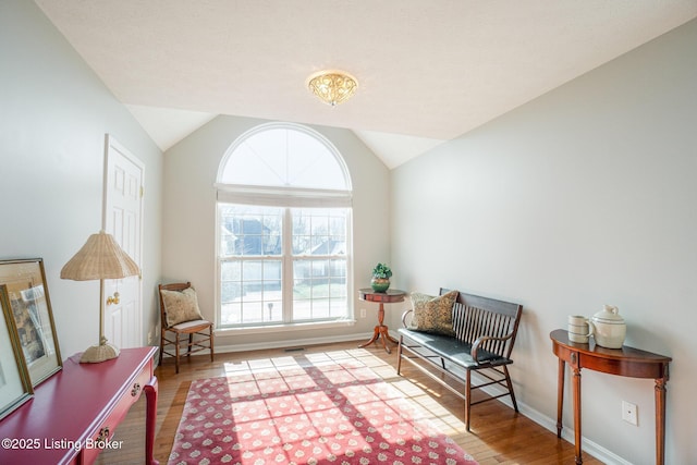 sitting room featuring lofted ceiling and light hardwood / wood-style floors