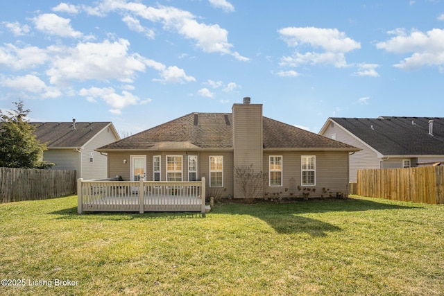 back of property featuring a wooden deck and a lawn