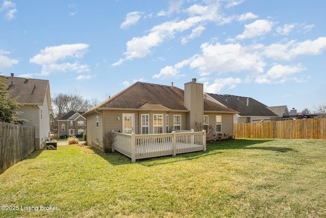 rear view of property with a wooden deck and a yard