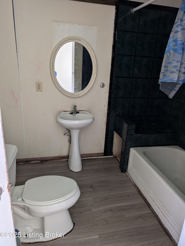 bathroom with wood-type flooring, toilet, and shower / bath combination