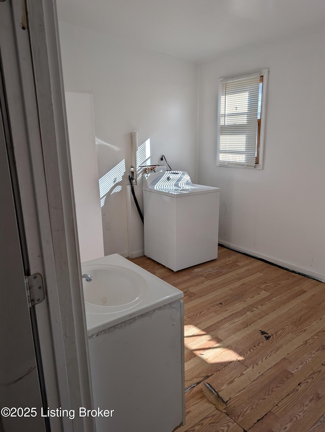 bathroom with hardwood / wood-style flooring, vanity, and washer / dryer