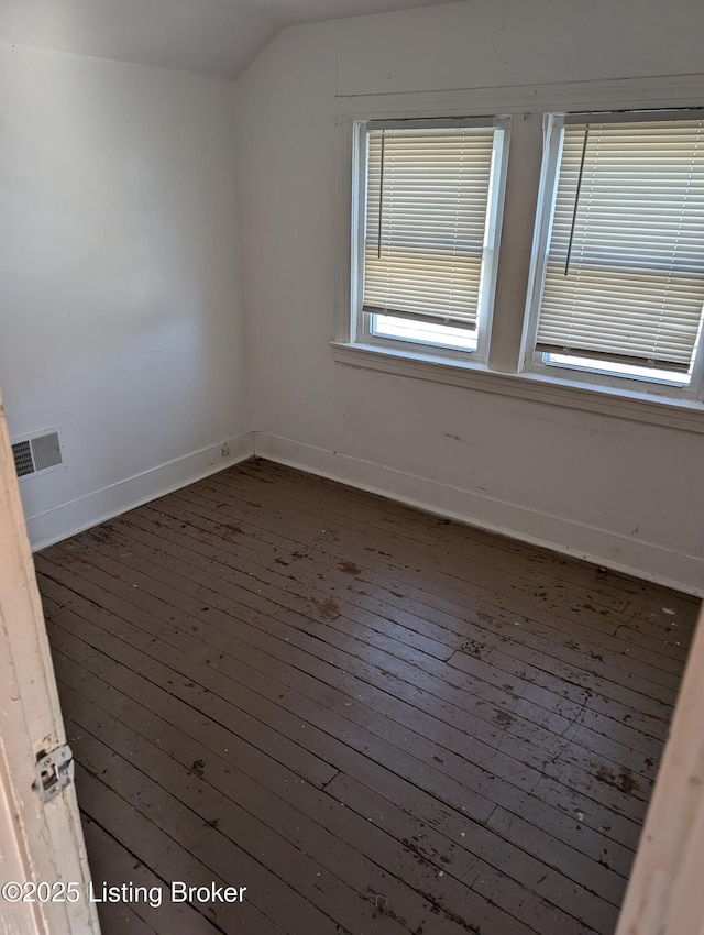 empty room with vaulted ceiling and dark wood-type flooring