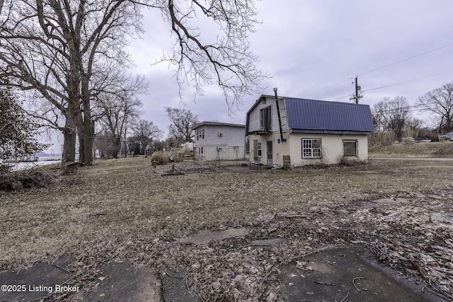 view of home's exterior with metal roof and a gambrel roof