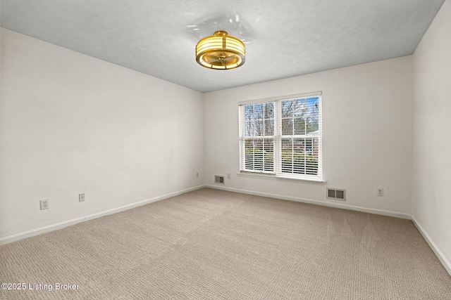 carpeted empty room with a textured ceiling