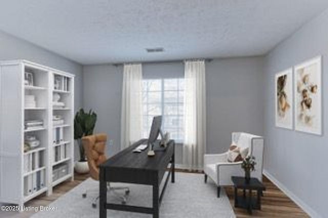 home office with a textured ceiling, baseboards, and wood finished floors