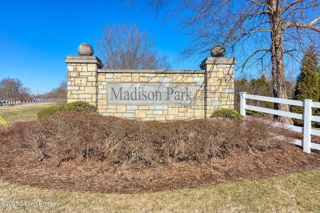 community / neighborhood sign featuring fence