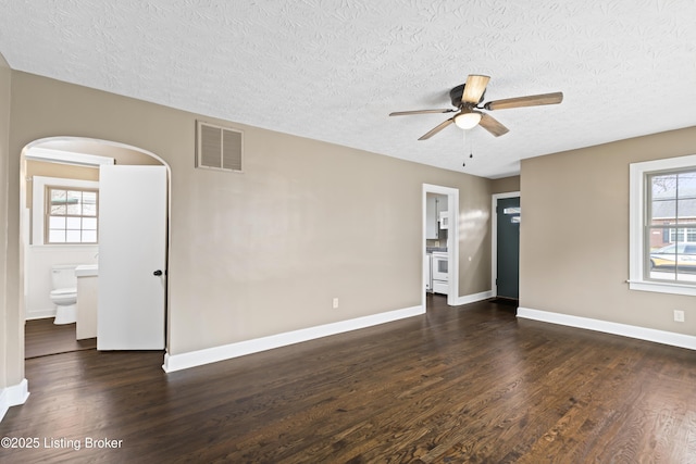 empty room featuring ceiling fan, a textured ceiling, and dark hardwood / wood-style flooring