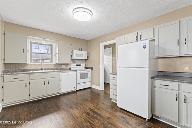 kitchen featuring sink, white appliances, a textured ceiling, white cabinets, and dark hardwood / wood-style flooring