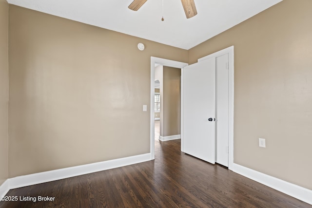 spare room featuring dark wood-type flooring and ceiling fan