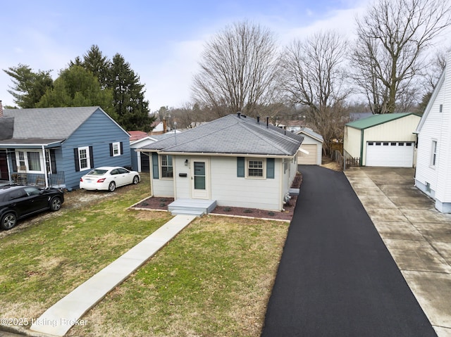 view of front of house with a garage, an outdoor structure, and a front lawn