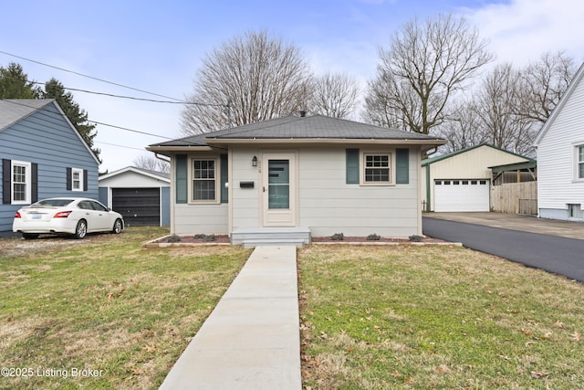 bungalow with an outbuilding, a garage, and a front yard