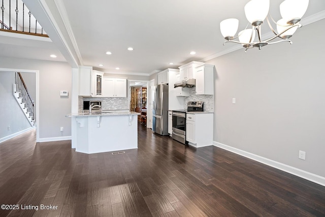 kitchen with appliances with stainless steel finishes, sink, white cabinets, a kitchen breakfast bar, and light stone countertops