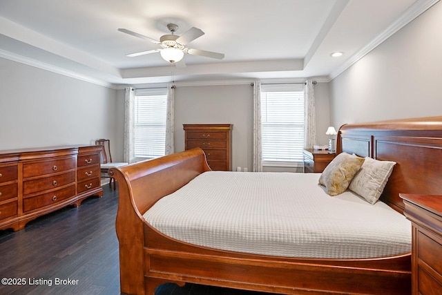 bedroom featuring a raised ceiling, crown molding, dark hardwood / wood-style floors, and ceiling fan