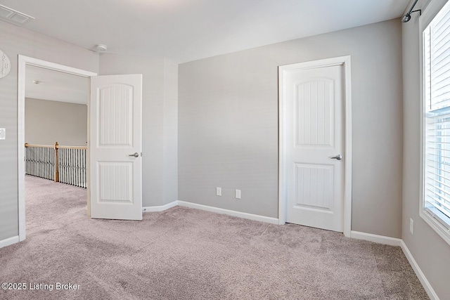 empty room featuring light colored carpet and a wealth of natural light