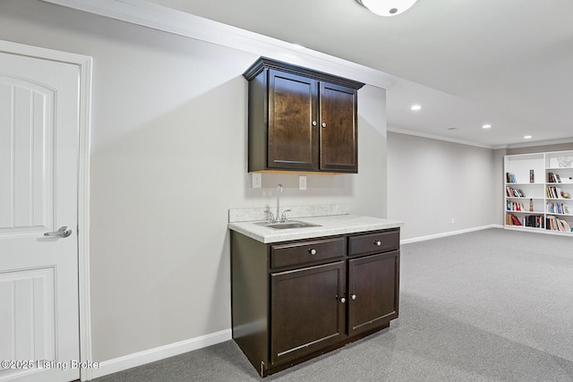 bar featuring dark brown cabinets, sink, and light colored carpet