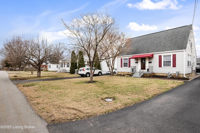 cape cod home with a front yard