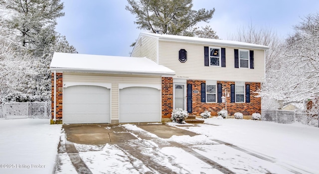 view of front of property featuring an attached garage, driveway, fence, and brick siding