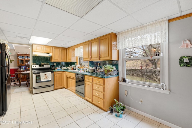 kitchen with black appliances, sink, light tile patterned floors, a paneled ceiling, and decorative backsplash